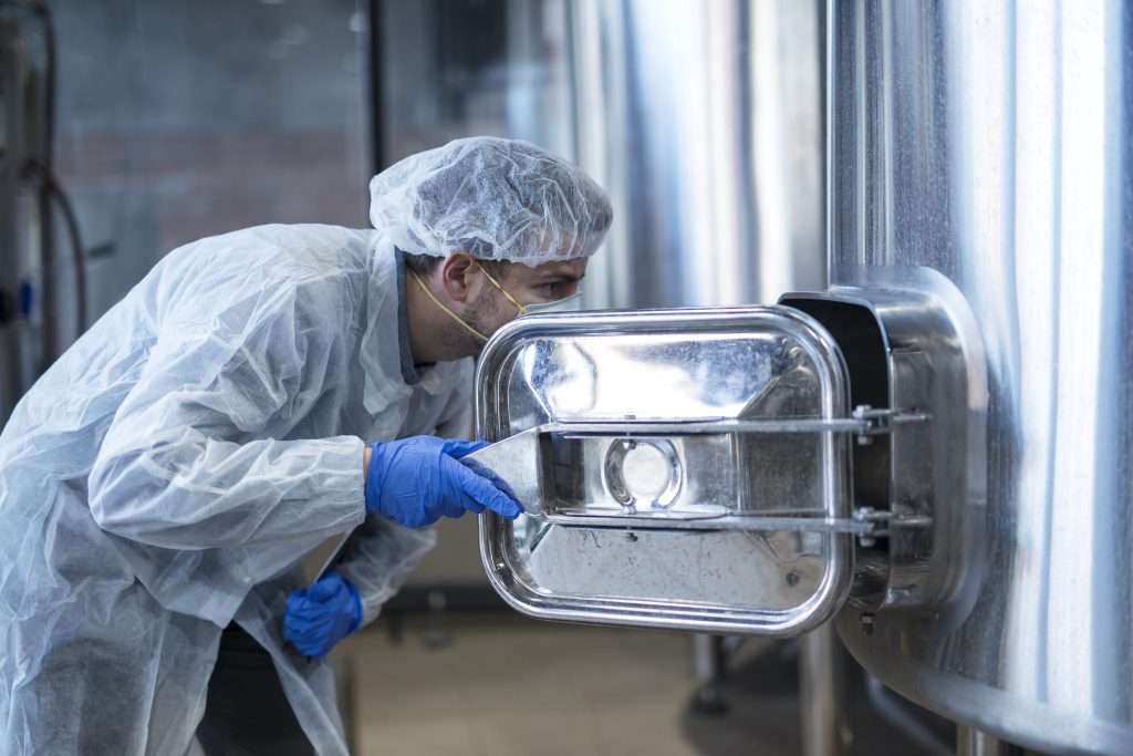 Climate-Controlled Confidence: How to Buy Used Environmental Chambers at Auction 6 technologist white suit looking inside machine food factory production line